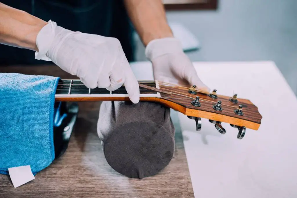 acoustic guitar repairman fixing the guitar neck