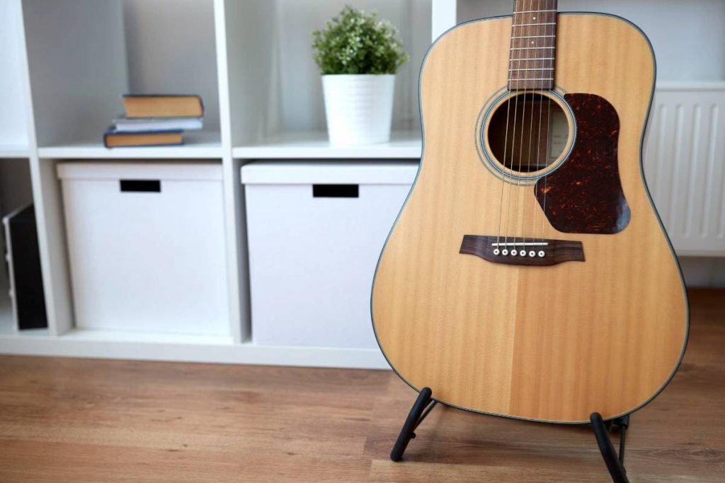 close up of acoustic guitar on stand at home