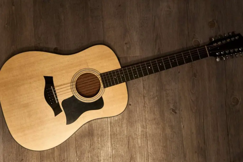 full 12string acoustic guitar on a brown wooden floor