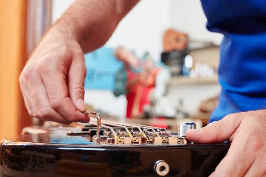 guitar maker adjusts electric guitar with precision
