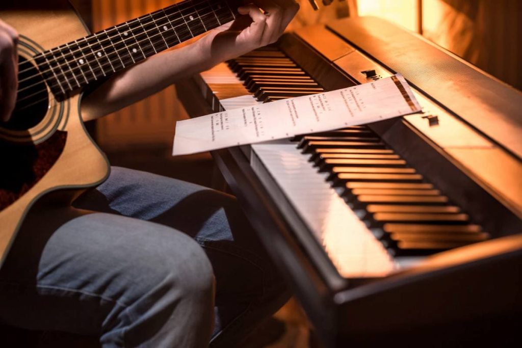 man playing acoustic guitar and piano