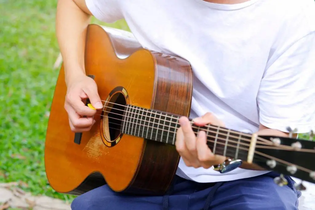 man playing acoustic guitar in the garden