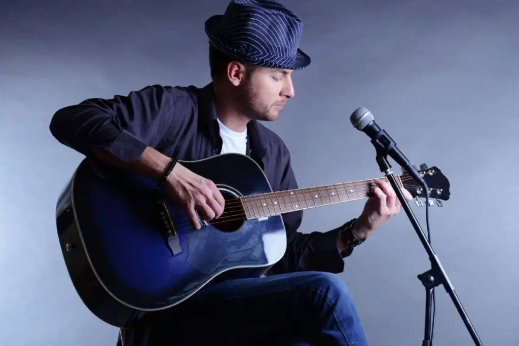 musician playing acoustic guitar