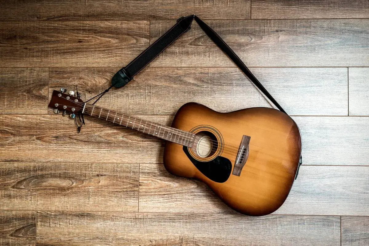 older acoustic guitar hanging the wall