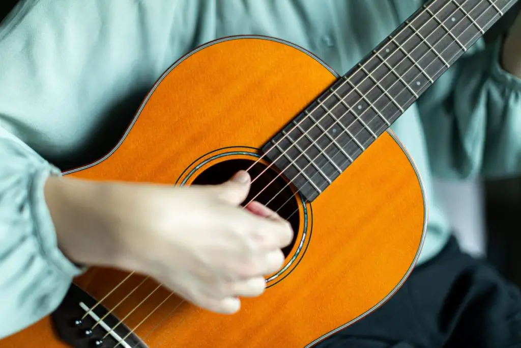 strum an acoustic guitar with too much power