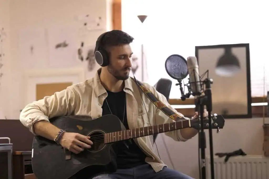 Recording Latency Fix: 8 Easy Steps for Perfect Timing 2026 1 Musician wearing headphones at a microphone in a home studio, recording latency fix
