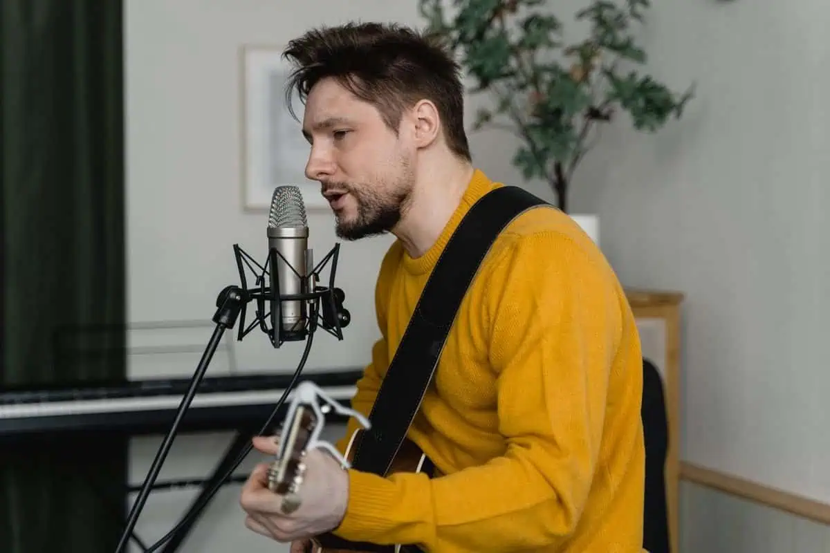 A songwriter singing and playing acoustic guitar to test how to write lyrics that fit the melody