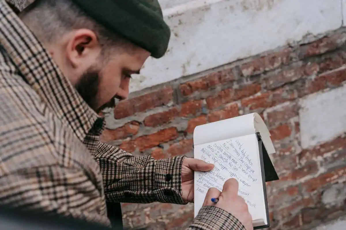 How to write lyrics: a songwriter writing song lyrics in a notebook