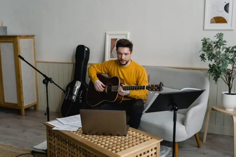 Best Online Guitar Lessons 2026: 6 Proven Platforms for Remote Learning 3 Guitarist following the best online guitar lessons on a laptop at home
