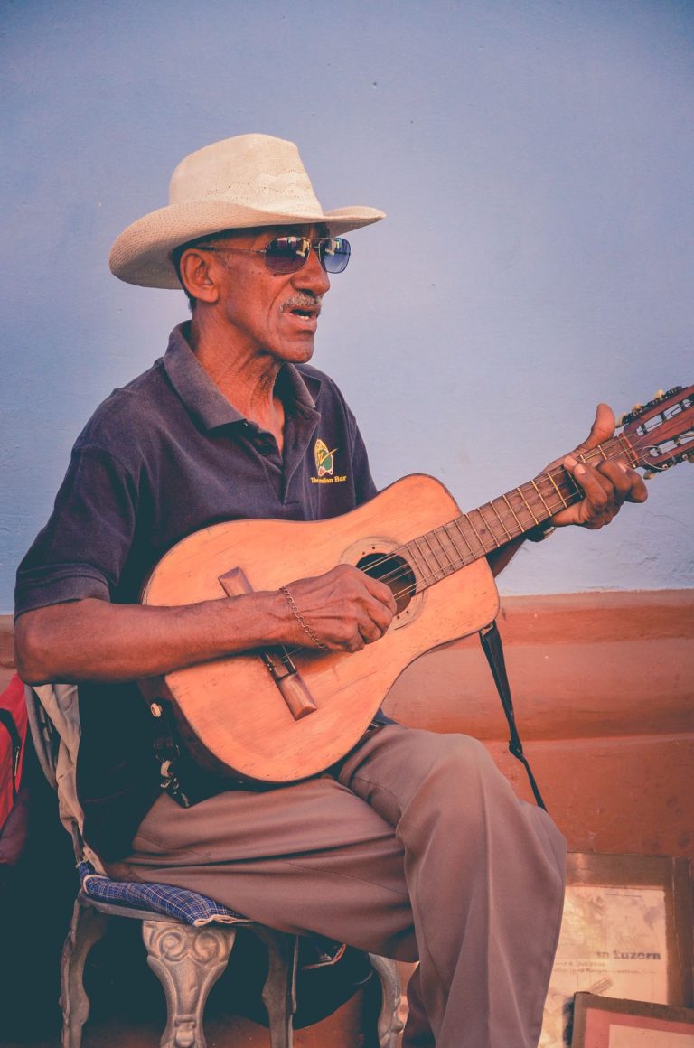 Is Suno Free? Plans, Credits & Download Limits Explained 2026 3 Guitarist playing a wide neck guitar with relaxed fretting hand