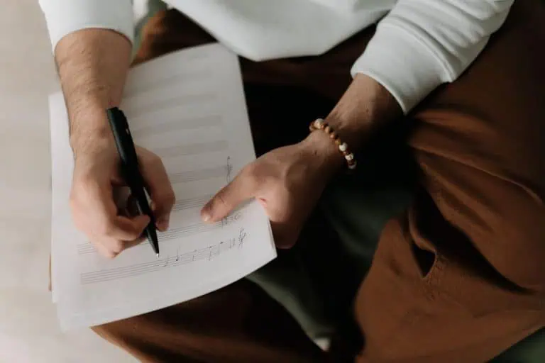 How to collect songwriting royalties: songwriter writing lyrics on sheet music